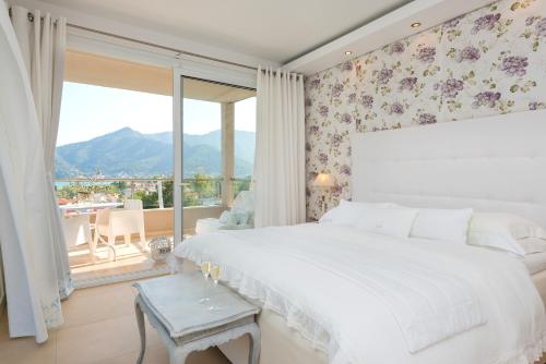 a bedroom with a large bed and a large window at Mare Monte Small Boutique Hotel in Chrysi Ammoudia
