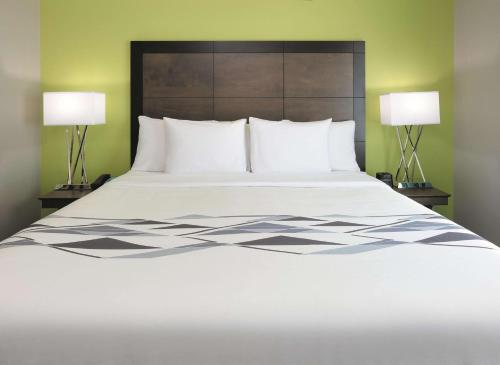 a bedroom with a large bed with two lamps at La Quinta by Wyndham Tyler South in Tyler