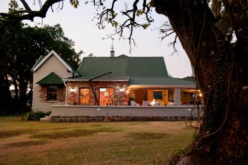 a house with a green roof with lights on it at Dalmore Guest Farm in Bergville
