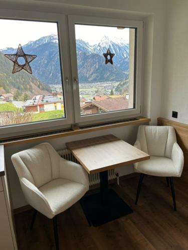 a room with two chairs and a table and two windows at Haus Sonnegg in Finkenberg