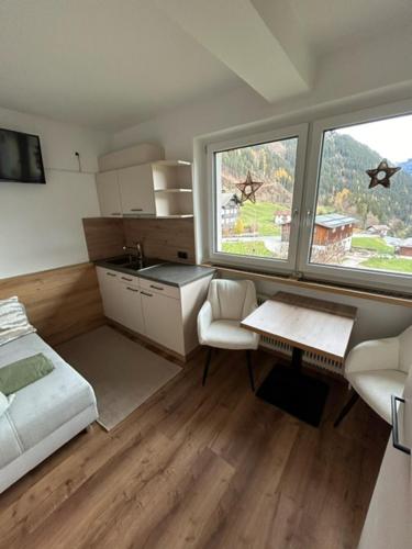 a room with a bed and a kitchen with a window at Haus Sonnegg in Finkenberg