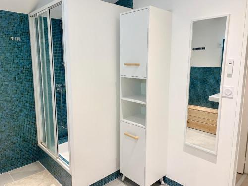 a bathroom with white cabinets and a mirror at Le Beuty in La Bresse