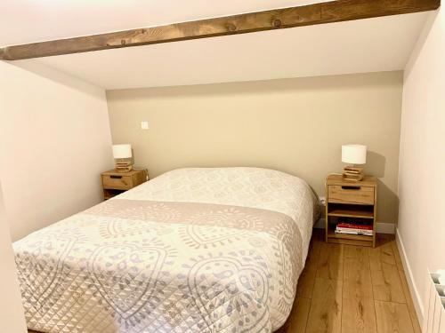 a bedroom with a bed and two night stands at Le Beuty in La Bresse