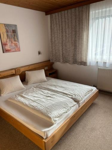 a bedroom with a bed in a room with a window at Haus Sonnegg in Finkenberg