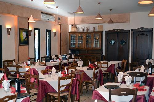 a dining room with white tables and chairs with red flowers at Hotel Immagine in San Giovanni Rotondo
