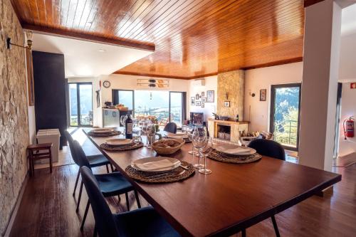 a dining room with a large wooden table and chairs at Blue Lake House in Ferreira do Zêzere