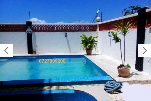 a swimming pool in front of a house at Shanzu Mombasa One Bedroom & Swimming Pool in Shanzu
