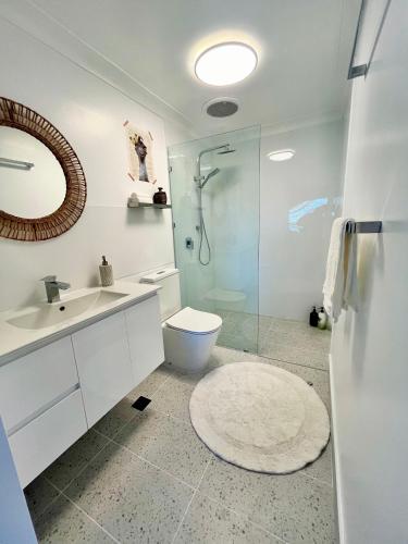 a bathroom with a toilet and a glass shower at Point Clare - Relax and unwind - Greenery & Birdsongs in Point Clare