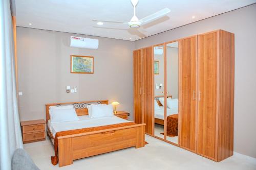 une chambre avec un lit et un grand miroir dans l'établissement StayAfrica, à Ouagadougou