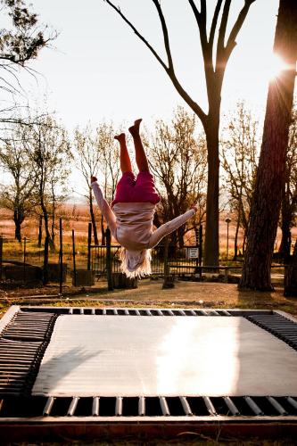 a woman jumping on top of a trampoline at Dalmore Guest Farm in Bergville