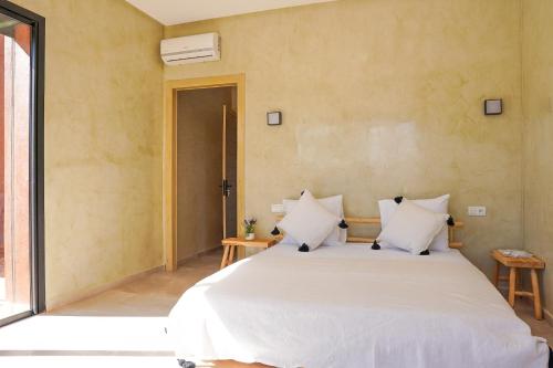 a bedroom with a large bed with white sheets at VILLA NOÛR PALACE avec piscine jaccuzi à Marrakech in Marrakech