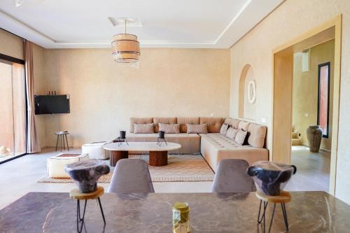 a living room with a couch and a table at VILLA NOÛR PALACE avec piscine jaccuzi à Marrakech in Marrakech