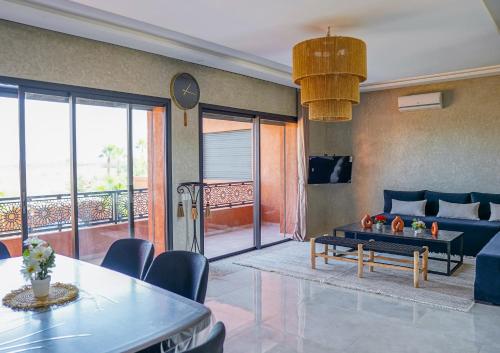 a living room with a blue couch and a table at VILLA NOÛR PALACE avec piscine jaccuzi à Marrakech in Marrakech