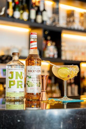 a bottle of whisky and a drink on a bar at Breeze Hotel in Calais