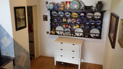 a room with a shelf with dishes and a dresser at Seehaus Weiss in Rothenthurn