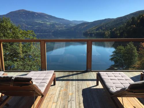 a deck with a view of a lake and mountains at Seehaus Weiss in Rothenthurn