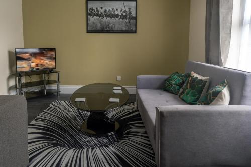 a living room with a couch and a table at City Centre One Bedroom Apartment Free Parking And internet in Hull