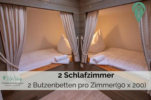 two beds in a small room with curtains at Butzenhuuske in Krummhörn