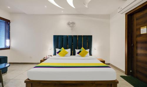 a bedroom with a large white bed with yellow pillows at Itsy Hotels Vedansh in Ludhiana