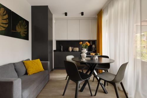 a living room with a table and a couch at Scala Apartamenty by Moderna Profit- Łąkowa 60C in Gdańsk