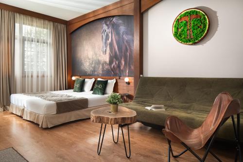 a bedroom with a bed and a couch and a table at Boutique Complex Trakiets in Zhitnitsa