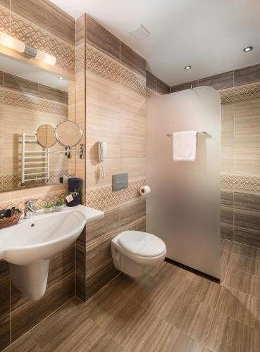 a bathroom with a white toilet and a sink at Boutique Complex Trakiets in Zhitnitsa