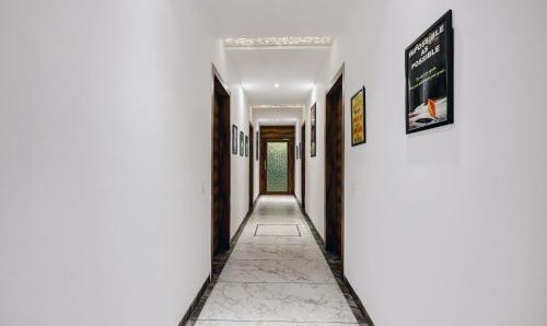 a corridor of a hallway with white walls and white floors at Itsy Hotels Vedansh in Ludhiana