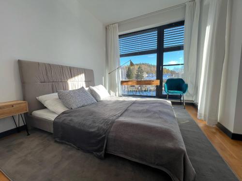 a bedroom with a bed and a large window at Happy Moments - widokowy apartament in Jelenia Góra
