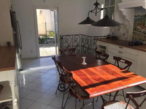 une salle à manger avec une table et des chaises et une cuisine dans l'établissement Appartement confortable à Plan-de-Cuques avec piscine privée, à Plan-de-Cuques