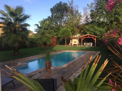une piscine dans un jardin avec un kiosque dans l'établissement Appartement confortable à Plan-de-Cuques avec piscine privée, à Plan-de-Cuques