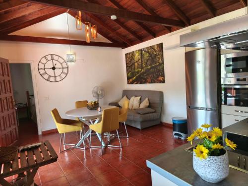 Una cocina y una sala de estar con mesa y sillas. en La Finca De Victoria Alojera, en Vallehermoso