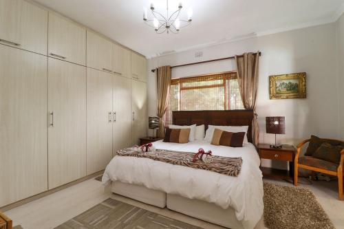 ein Schlafzimmer mit einem großen Bett mit roten Bögen darauf in der Unterkunft Pelican Place Guest Cottages in Durbanville