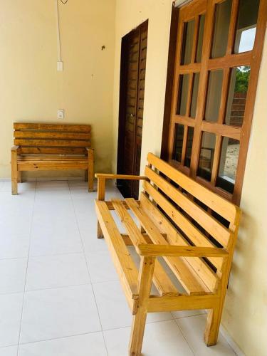 two wooden benches sitting next to a door at Casadijaina in Amontada