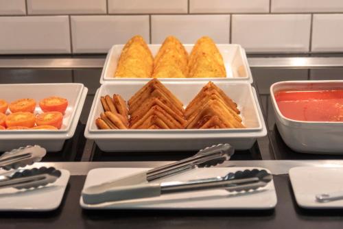 a tray of food with waffles and crackers on a table at Holiday Inn Express Belfast City by IHG in Belfast