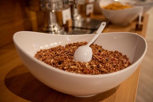 a white bowl of cereal with a spoon in it at Holiday Inn Express Belfast City by IHG in Belfast