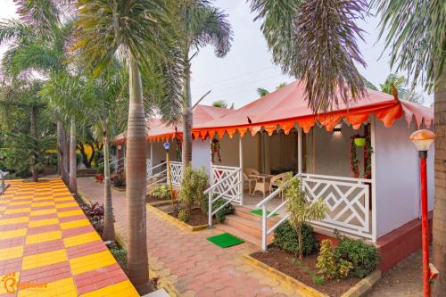 una casa con palmeras junto a una pasarela en Natures Dreamland Holiday Homes, Igatpuri, en Igatpuri