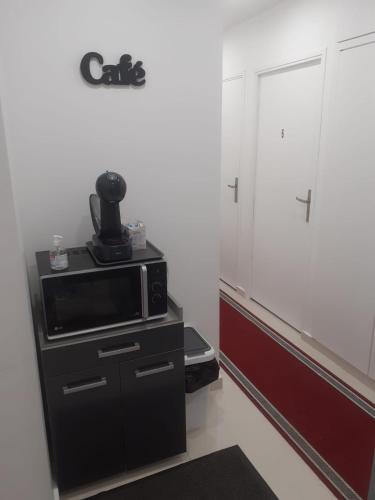 - un four micro-ondes installé au-dessus d'une armoire noire dans l'établissement Love Room Romantique, à Tremblay-en-France