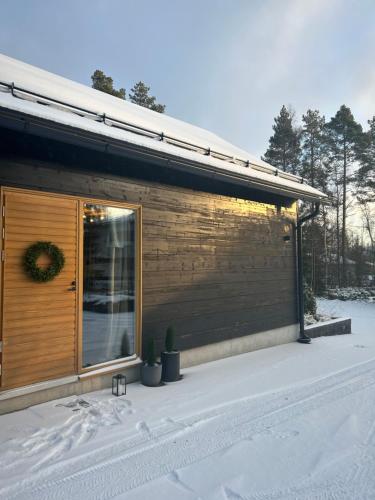 奥卢Log cabin of peace的雪中带滑动玻璃门的房子