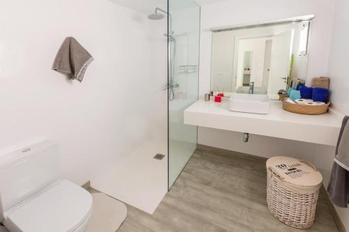 Un baño con inodoro, lavabo y espejo. en Lanzahost Tabaiba Blue, en Costa Teguise