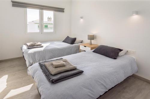 Un dormitorio con dos camas y una ventana. en Lanzahost Tabaiba Blue, en Costa Teguise