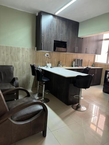 eine Küche mit einer Bar mit Stühlen und einem Waschbecken in der Unterkunft Feel At Home Away From Home in Durban