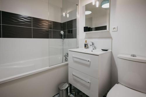 a white bathroom with a sink and a toilet at Loft lumineux ! wifi à 20min de Rennes in Bain-de-Bretagne