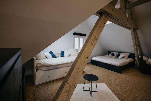 a attic room with two beds and a stool at Loft lumineux ! wifi à 20min de Rennes in Bain-de-Bretagne