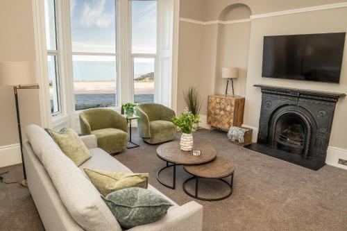 a living room with a couch and a fireplace at King's Seafront Place in Cullercoats