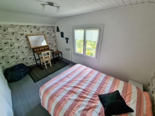 une chambre avec un lit, un miroir et une table dans l'établissement La Cabane aux Acacias~vacances nature et au calme, à Mézos