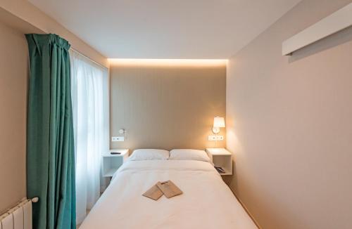 a bedroom with a bed with a book on it at La Lonja in Alicante