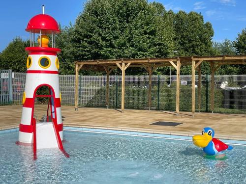 une piscine avec un jouet dans l'eau à côté d'un phare dans l'établissement Camping de Thoissey, à Thoissey