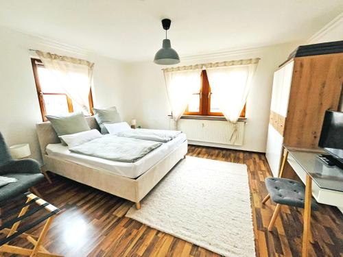 a bedroom with a bed and a desk and windows at Ferienwohnung Sankt Martin 225 N.N. in Sankt Martin