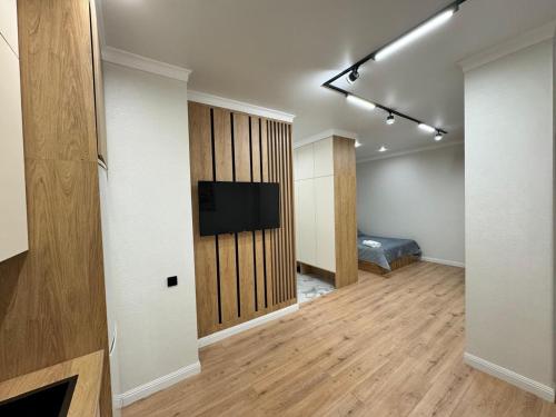 a room with a television and a bed in a room at Уютная квартира в Бухар Жырау in Astana