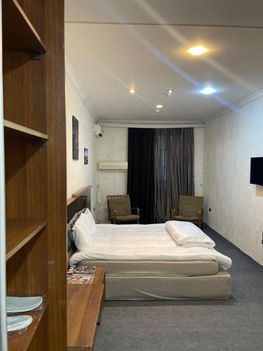 a hotel room with a bed and chairs in it at Abu Arena Hall in Baku